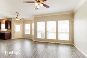 Spring house for rent - A spacious room with a ceiling fan and sliding glass doors.