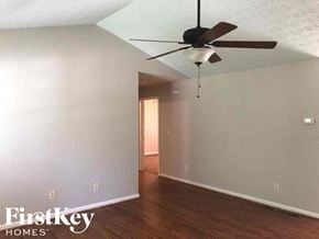 Gainesville house for rent - A room with a ceiling fan and wooden floors.