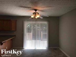 Gainesville house for rent - A room with a ceiling fan and a window with blinds.