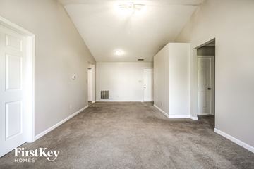 Indianapolis house for rent - a spacious living room with carpet and white walls