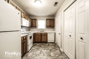 Indianapolis house for rent - a kitchen with white appliances and wooden cabinets
