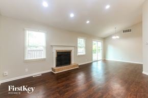 Indianapolis house for rent - A spacious room with a fireplace and wood flooring.