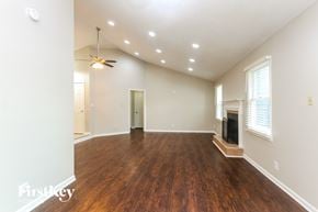 Indianapolis house for rent - A spacious room with wood flooring and a fireplace.