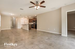 Wimauma house for rent - A spacious room with a ceiling fan and lighting fixtures.