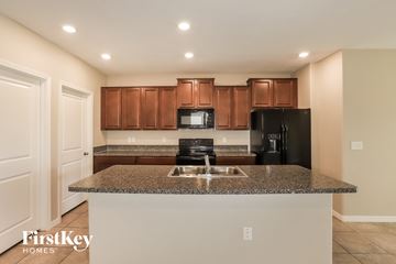 Wimauma house for rent - A kitchen with brown cabinets and a granite countertop.