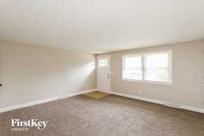 Kansas City house for rent - a bedroom with carpet and a door and two windows
