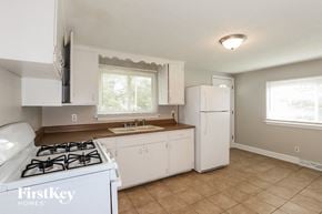 Kansas City house for rent - a kitchen with a stove and a sink and a refrigerator