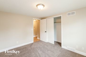 Kansas City house for rent - a spacious living room with carpet and a door to a closet