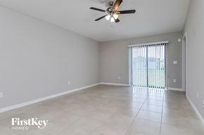 Wimauma house for rent - A spacious room with a ceiling fan and sliding glass doors.