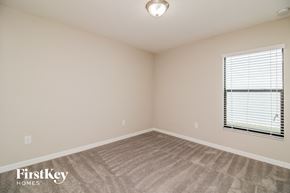 Wimauma house for rent - A room with a carpeted floor and a window with blinds.