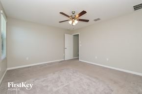 Wimauma house for rent - A spacious room with a ceiling fan and a door in the middle.
