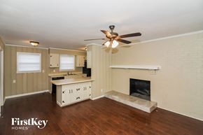 Memphis house for rent - A well-lit room with a fireplace and a ceiling fan.