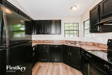 Indianapolis house for rent - A kitchen with black cabinets and a wooden island.