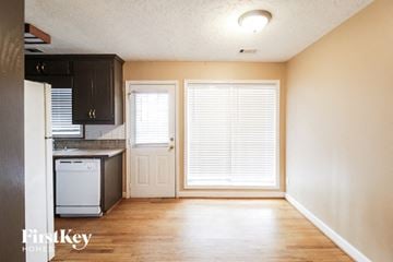 Flowery Branch house for rent - a small kitchen with a window and a white stove and refrigerator