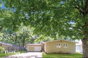 Kansas City house for rent - a house with a garage and a tree in front of it