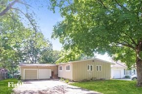Kansas City house for rent - a yellow house with a garage and a tree