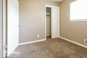 Kansas City house for rent - a bedroom with a carpeted floor and a door to a closet