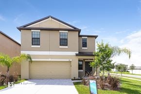 Wimauma house for rent - A two-story house with a garage and a driveway.