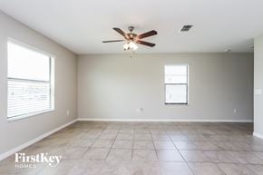 Wimauma house for rent - A spacious room with a ceiling fan and tiled floor.