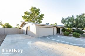 Tempe house for rent - A house with a garage and a driveway in front of it.