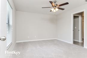 Wimauma house for rent - a bedroom with a ceiling fan and a door to a closet