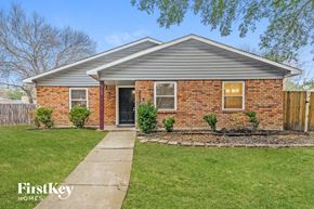 The Colony house for rent - A brick house with a grey roof and a black door.
