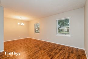 The Colony house for rent - A room with wooden flooring and a window with blinds.