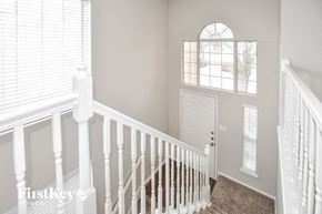 Garland house for rent - A white staircase with a carpeted floor and a white door.