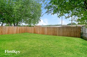 Garland house for rent - A backyard with a wooden fence and a grassy lawn.