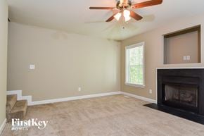 Winston-Salem house for rent - A living room with a fireplace and a ceiling fan.