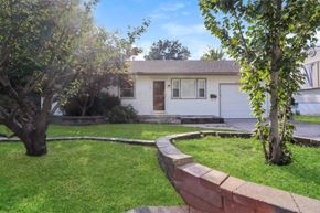 Independence house for rent - the front of a white house with a yard and a retaining wall