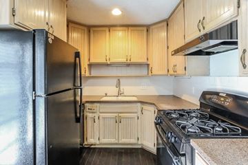 Independence house for rent - a kitchen with a stove and refrigerator and wooden cabinets