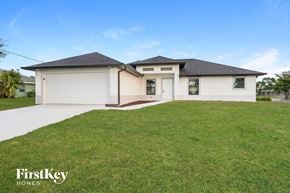 Lehigh Acres house for rent - a white house with a lawn in front of it