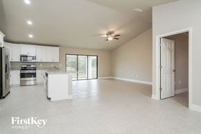 Lehigh Acres house for rent - an empty kitchen and living room with a ceiling fan