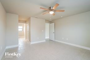 Lehigh Acres house for rent - a spacious living room with a ceiling fan and white tile floors