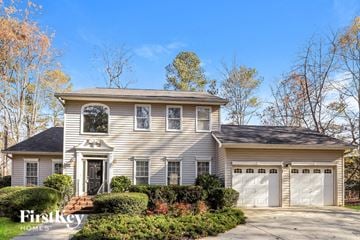Gainesville house for rent - a white house with two garage doors and a driveway