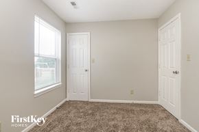Indianapolis house for rent - a bedroom with carpet and two doors and a window