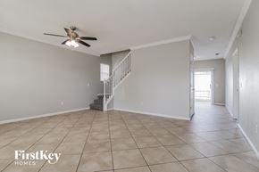 Orlando house for rent - A spacious room with a staircase and a ceiling fan.