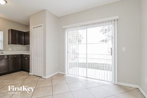 Orlando house for rent - A kitchen area with a white door and a sliding glass door leading to a balcony.