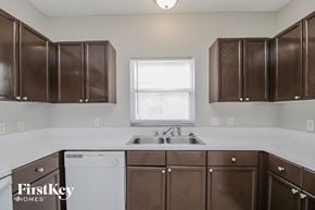 Orlando house for rent - A kitchen with brown cabinets and a white dishwasher.
