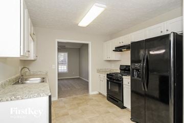 Dallas house for rent - a kitchen with black appliances and white cabinets