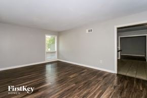 Memphis house for rent - A room with wooden flooring and a sliding door leading to another room.