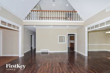 Memphis house for rent - A spacious room with wooden floors and a staircase with white railings.