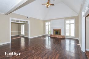 Memphis house for rent - A spacious room with a fireplace and wood flooring.