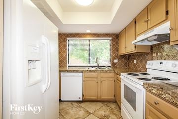 Glendale house for rent - a kitchen with white appliances and wooden cabinets