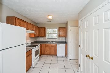 Union City house for rent - A kitchen with white appliances and wooden cabinets.