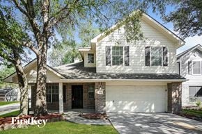 Humble house for rent - A house with a garage and a tree in front of it.