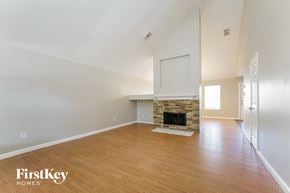 Humble house for rent - A spacious room with a fireplace and wooden flooring.