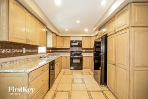 Hanover Park house for rent - a large kitchen with wood cabinets and black appliances