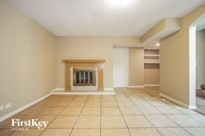 Hanover Park house for rent - a large living room with a fireplace and tiled floors